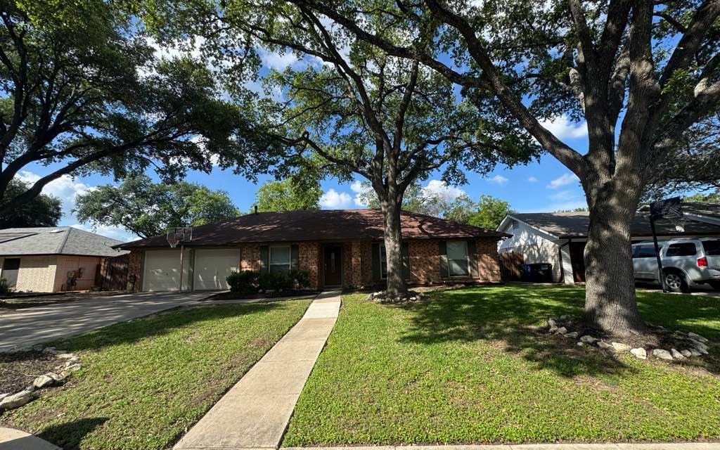 Freshly mowed, oak-framed front lawn in Converse, TX