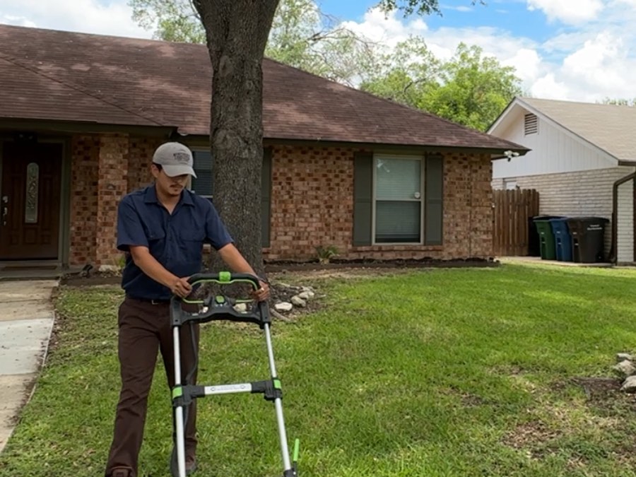 Alejandro, owner of Simply Lawn Care, mowing a yard in Converse, TX
